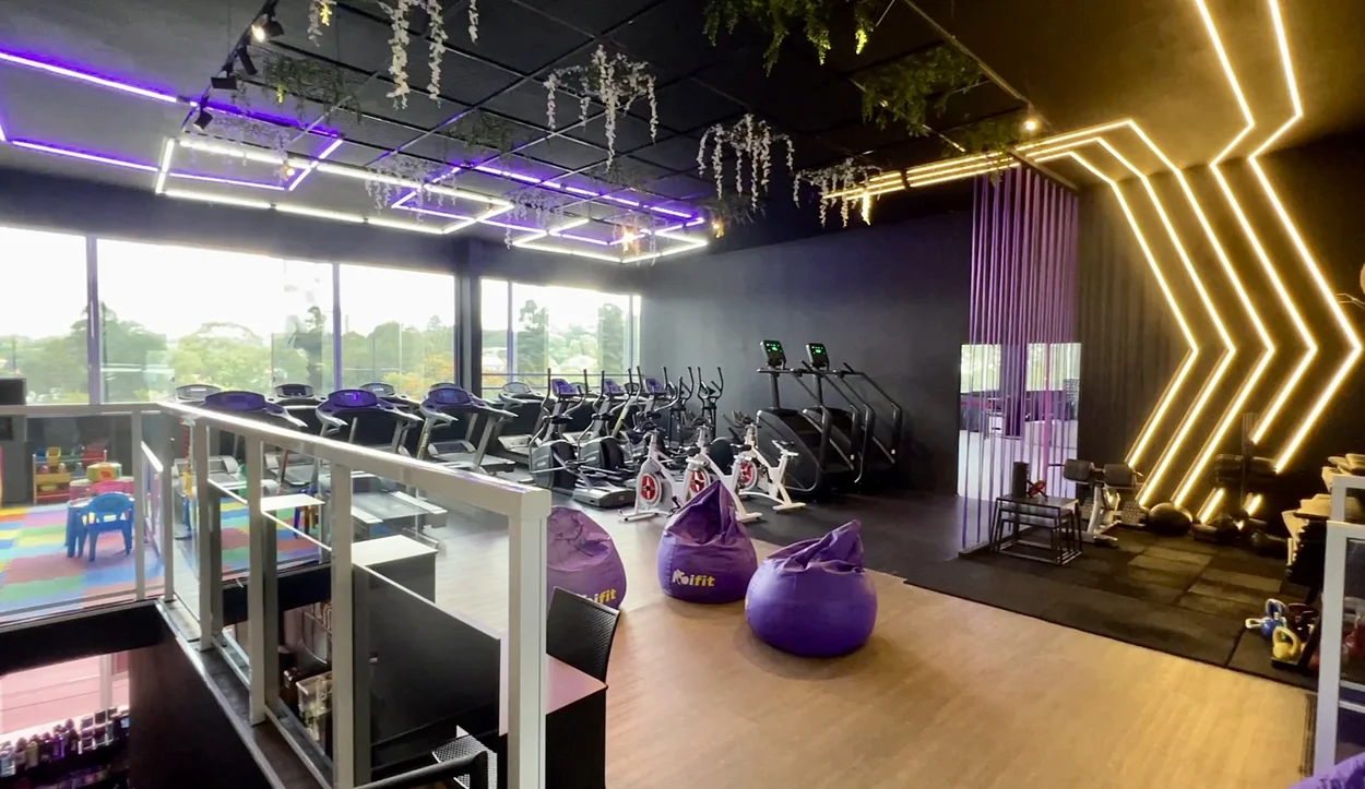 Área de cardio e convivência com vista ampla da academia.