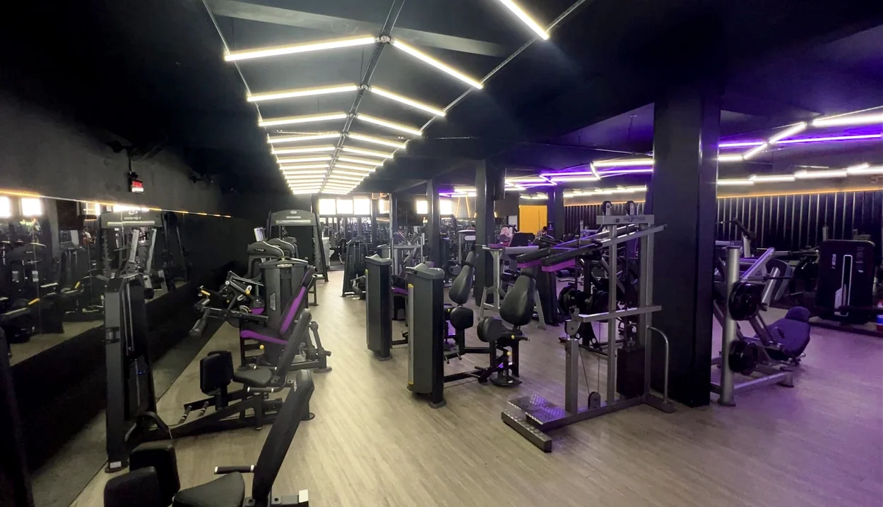 Corredor principal da musculação com máquinas alinhadas.